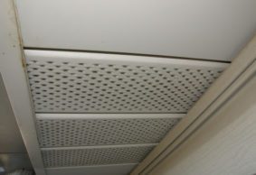 A close-up photo of soffit vents, which is white and has holes for ventilation